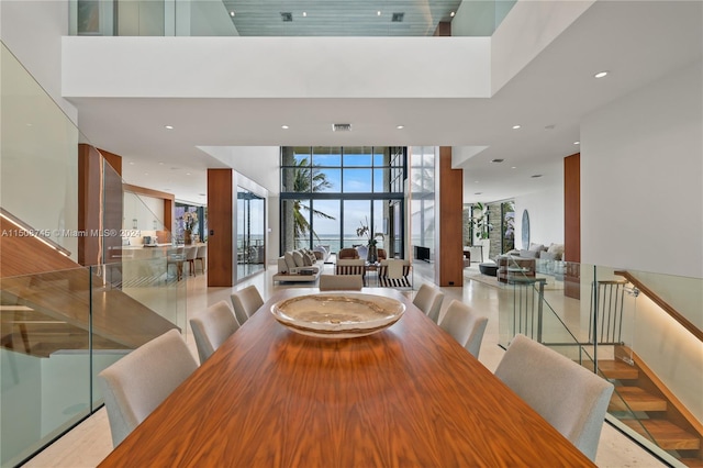 dining room featuring floor to ceiling windows and a towering ceiling