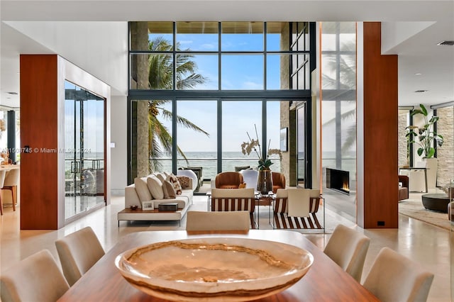 dining area with a water view and a wall of windows