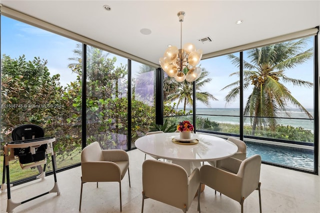 sunroom / solarium featuring a water view, a notable chandelier, and a healthy amount of sunlight