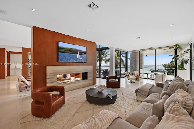 living room featuring a water view, floor to ceiling windows, and a healthy amount of sunlight