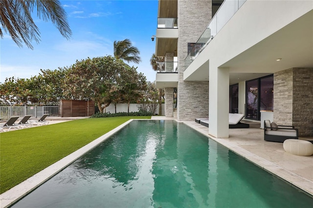 view of swimming pool with a yard and a patio