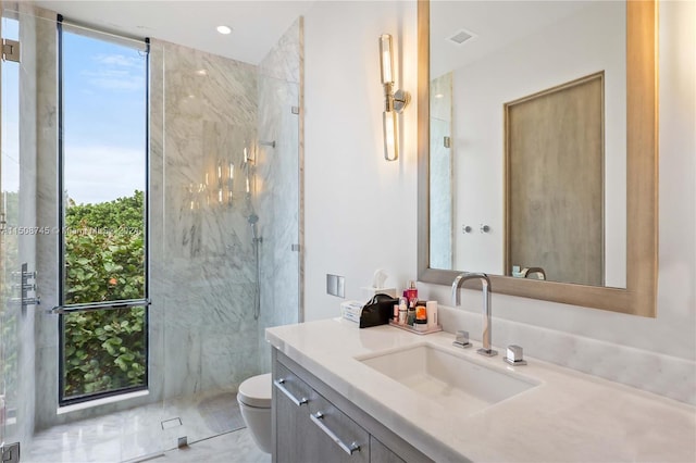 bathroom featuring toilet, an enclosed shower, plenty of natural light, and vanity