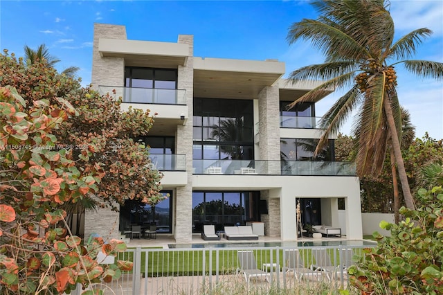 rear view of property featuring a balcony and a patio area