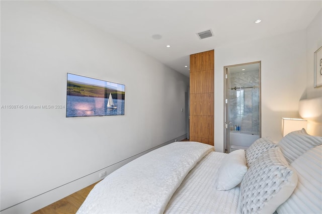 bedroom featuring light hardwood / wood-style flooring and ensuite bathroom