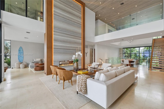 living room with a high ceiling and a wall of windows