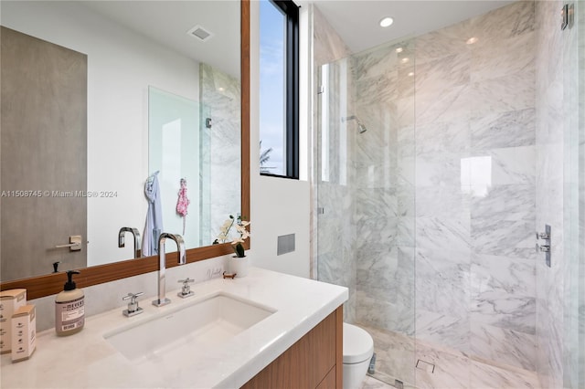 bathroom featuring vanity, toilet, and a tile shower