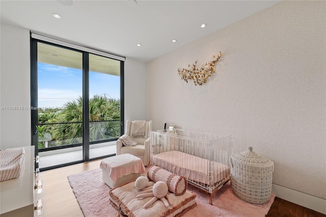 sitting room featuring plenty of natural light, expansive windows, and light wood-type flooring