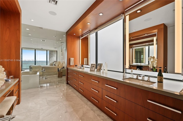 bathroom featuring vanity, a bath, and a water view