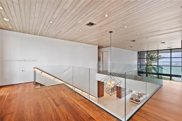 corridor featuring wood ceiling, hardwood / wood-style floors, and expansive windows