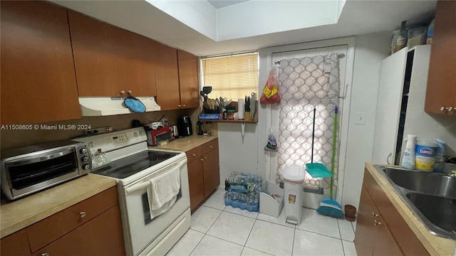 kitchen with sink, light tile patterned floors, and white electric stove