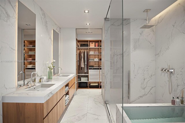 bathroom featuring dual vanity, a shower with shower door, tile walls, and tile patterned floors