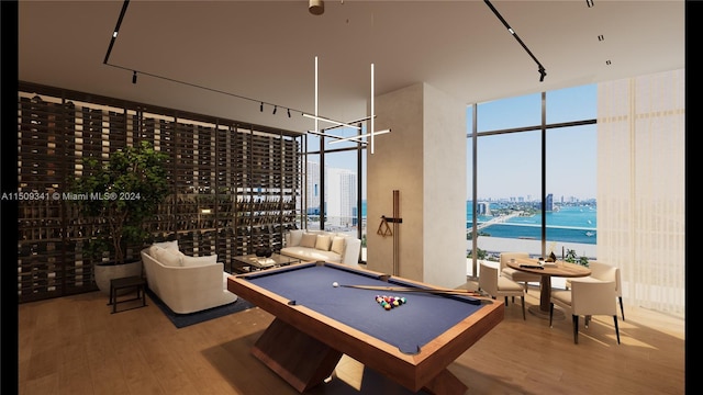 recreation room with a water view, billiards, wood-type flooring, and a wall of windows