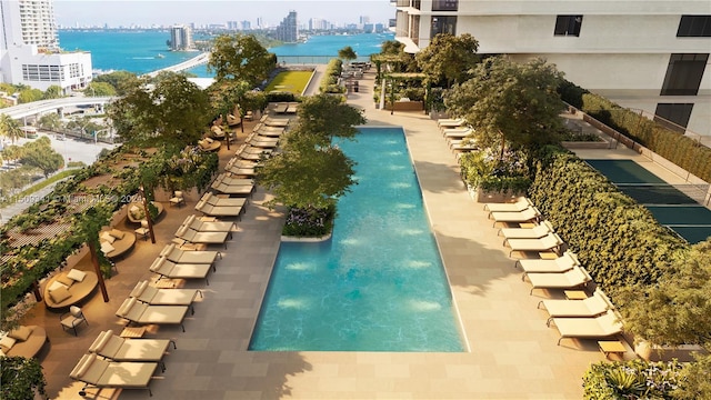 view of community with a patio area, a water view, and a pool