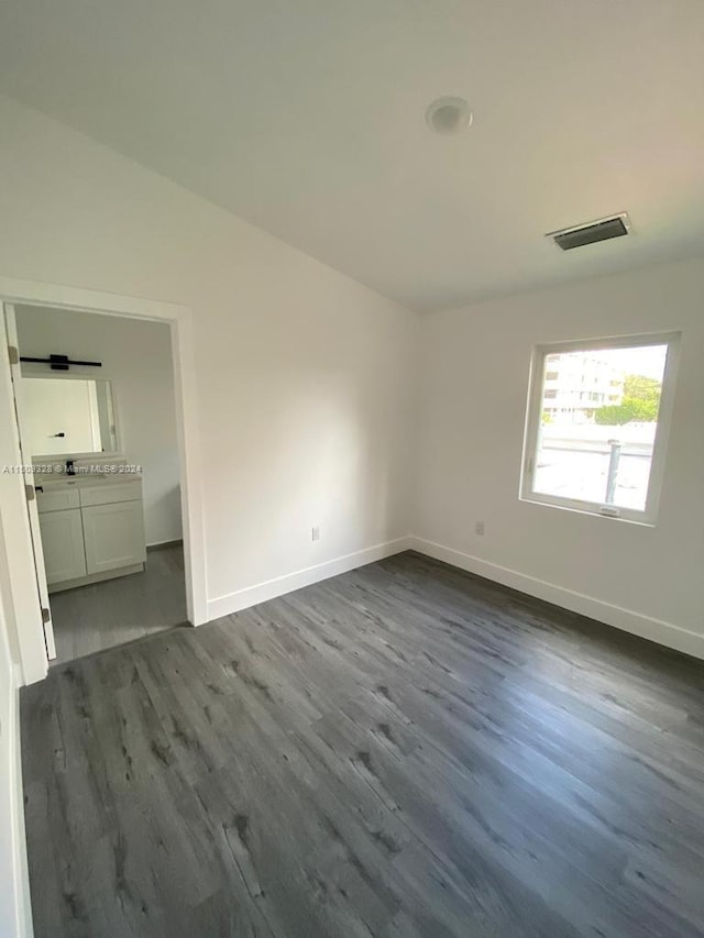 unfurnished room with dark wood-type flooring