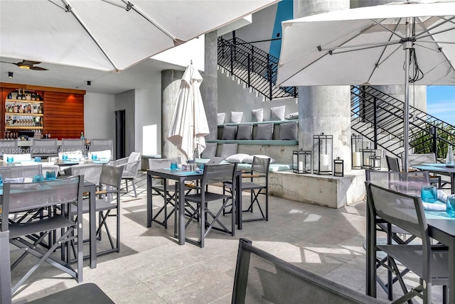 dining space featuring ceiling fan and indoor bar