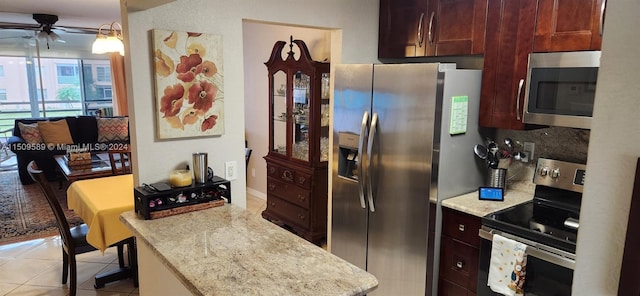 kitchen featuring backsplash, ceiling fan, stainless steel appliances, light tile floors, and pendant lighting