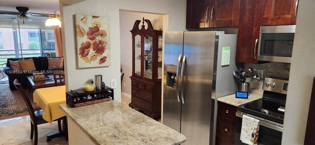 kitchen featuring appliances with stainless steel finishes, backsplash, light stone countertops, and sink