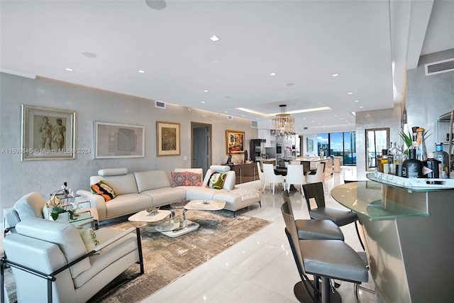 living room with a notable chandelier and light tile flooring