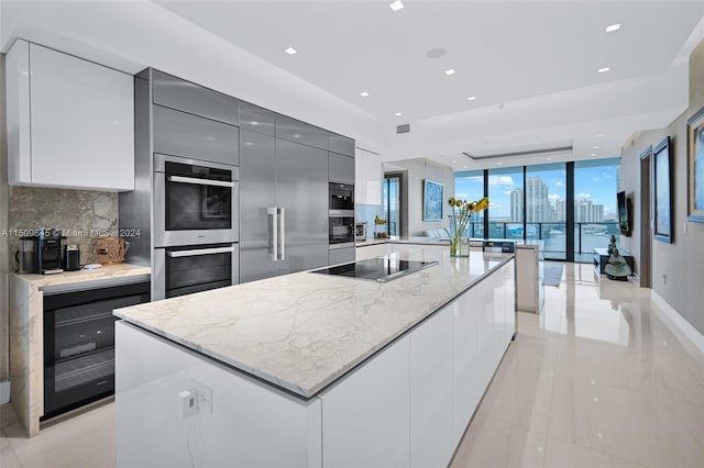 kitchen featuring beverage cooler, tasteful backsplash, light tile flooring, and a kitchen island