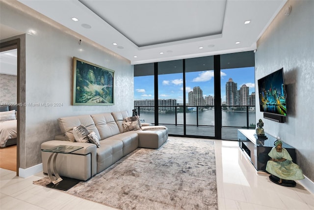 living room featuring a raised ceiling, floor to ceiling windows, and light tile floors