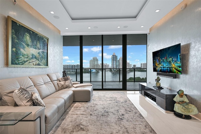 living room featuring floor to ceiling windows, plenty of natural light, and a raised ceiling