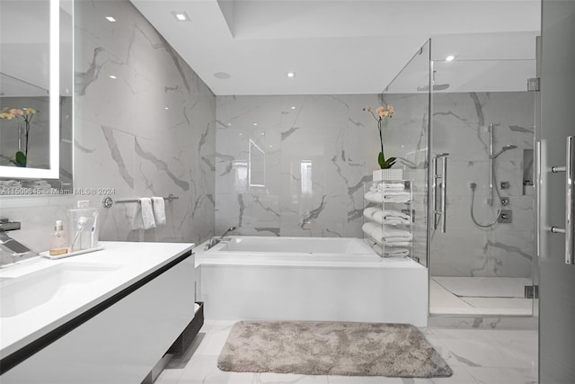 bathroom with tile walls, tile floors, separate shower and tub, and vanity