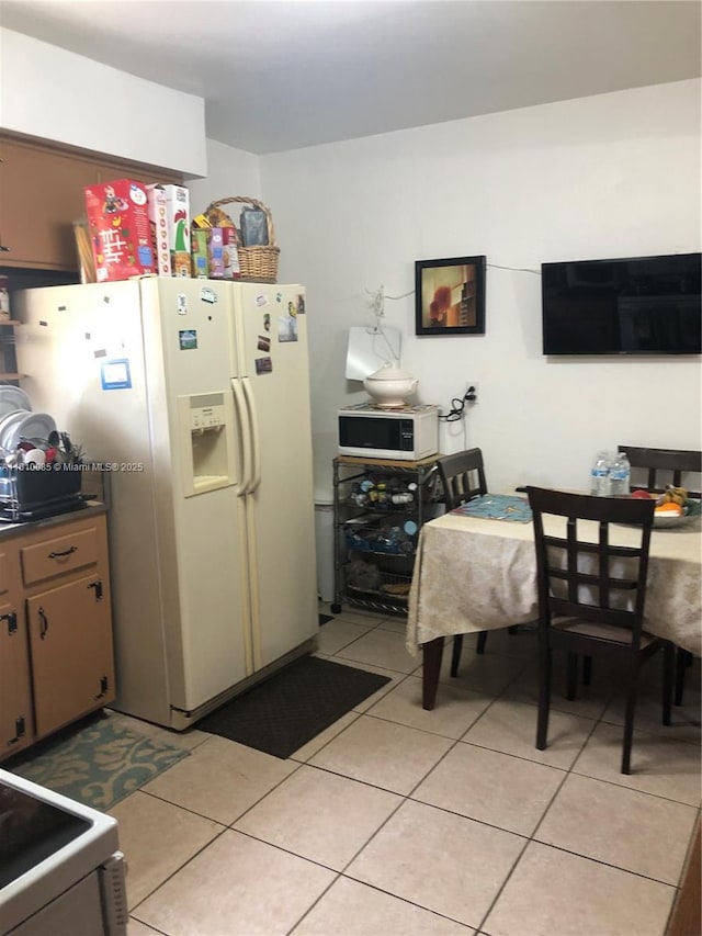 1256 NE 149th St, Miami, FL 33161 - kitchen with white appliances, light tile patterned floors, and dark countertops
