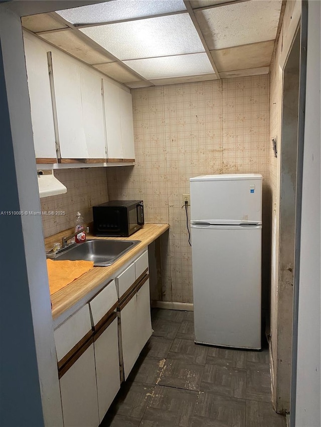 1256 NE 149th St, Miami, FL 33161 - kitchen with freestanding refrigerator, black microwave, white cabinetry, light countertops, and a sink