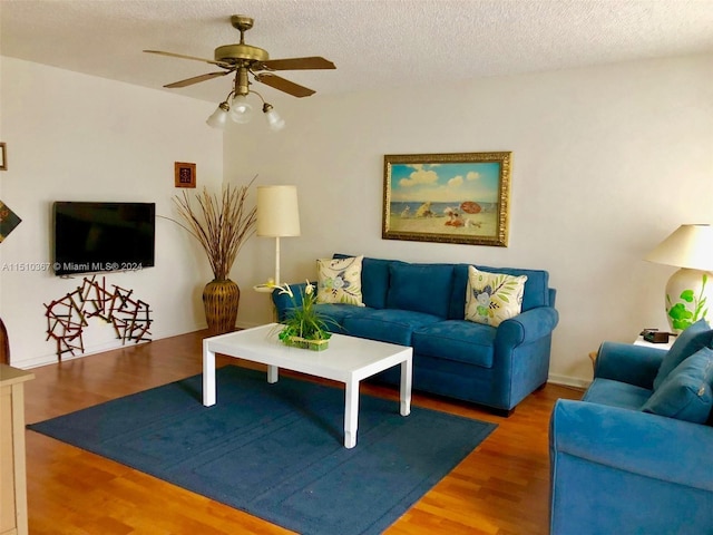 living room featuring a textured ceiling, ceiling fan, and hardwood / wood-style flooring