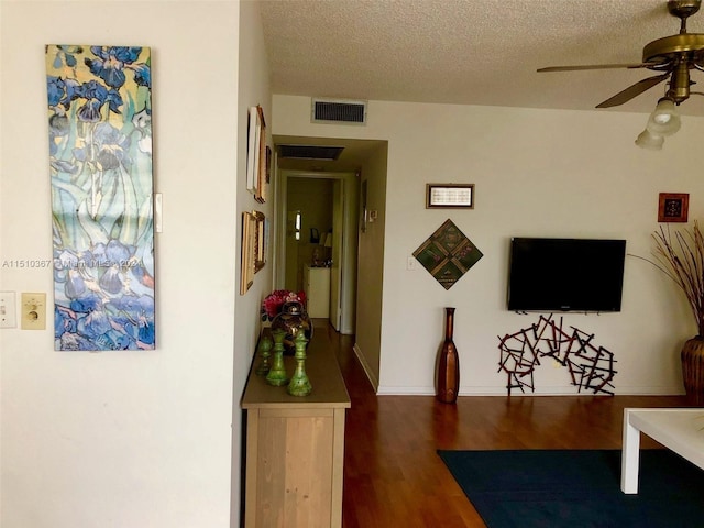 hall with dark hardwood / wood-style floors and a textured ceiling