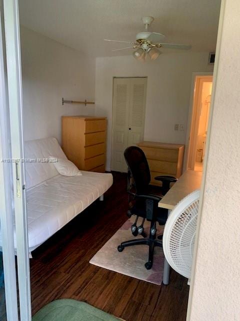 bedroom featuring a closet, dark hardwood / wood-style floors, and ceiling fan