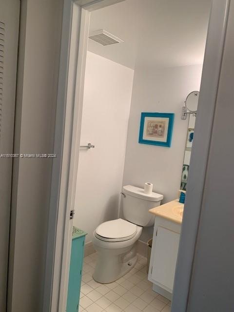 bathroom featuring vanity, tile flooring, and toilet