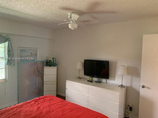 bedroom with ceiling fan and a textured ceiling