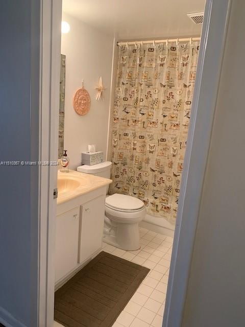 bathroom featuring toilet, tile floors, and vanity