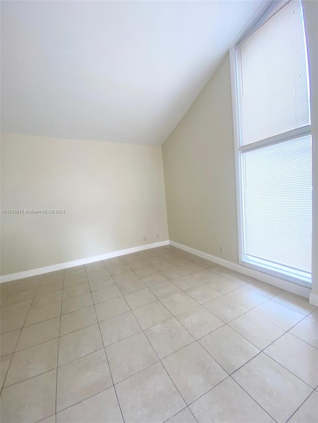 bonus room with vaulted ceiling and light tile floors