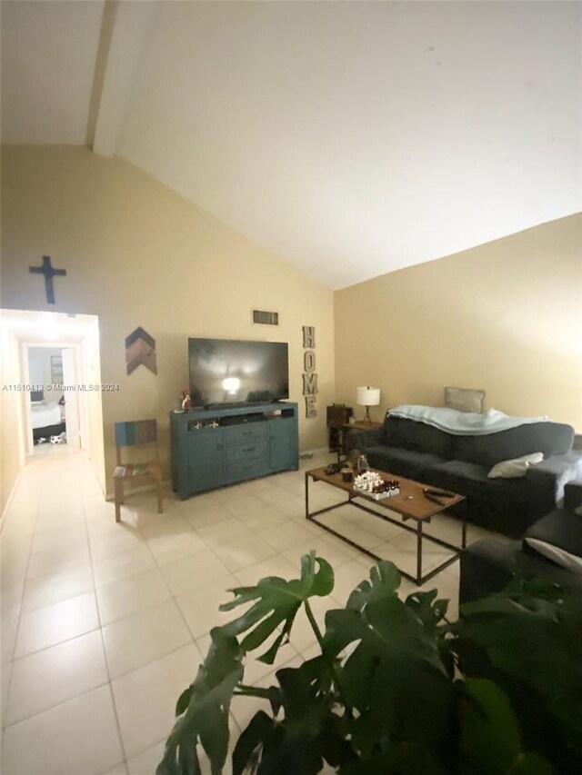 tiled living room featuring high vaulted ceiling and beam ceiling