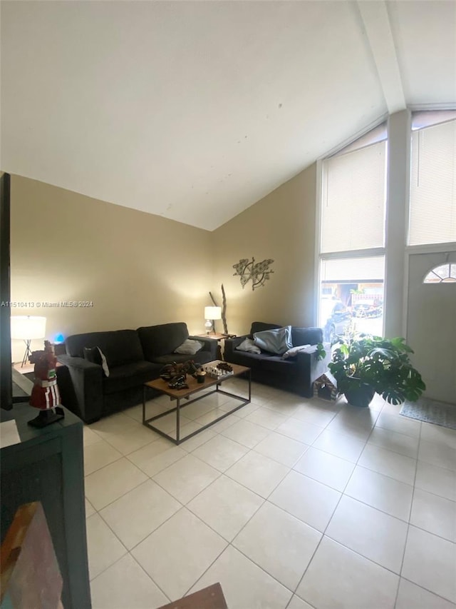 living room featuring vaulted ceiling with beams and light tile floors