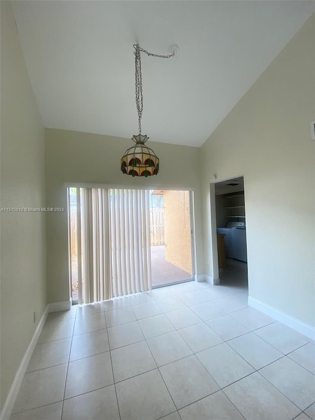 tiled empty room featuring a healthy amount of sunlight and lofted ceiling