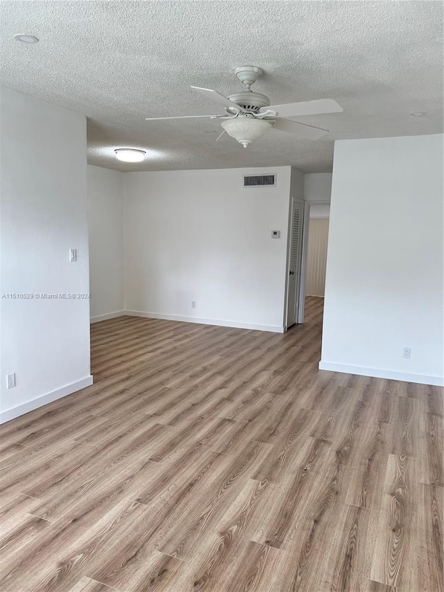 unfurnished room featuring a textured ceiling, ceiling fan, and light hardwood / wood-style floors