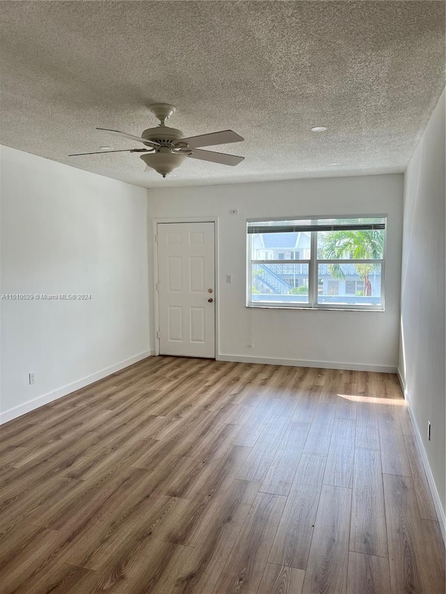 unfurnished room featuring a textured ceiling, hardwood / wood-style flooring, and ceiling fan