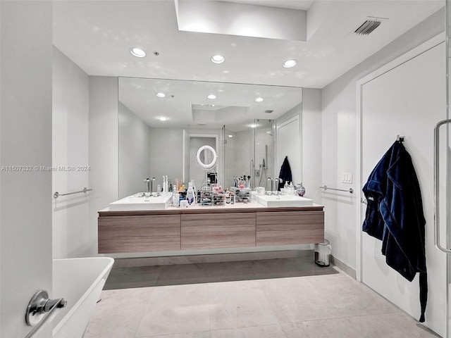 bathroom with tile flooring, a bath, oversized vanity, and double sink