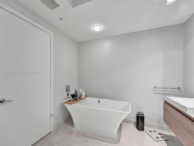 bathroom with tile flooring, vanity, and a washtub