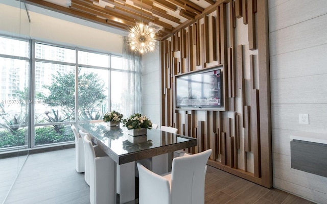 dining space with a notable chandelier, hardwood / wood-style flooring, and a wealth of natural light