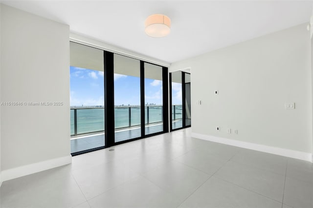 empty room featuring floor to ceiling windows and a water view