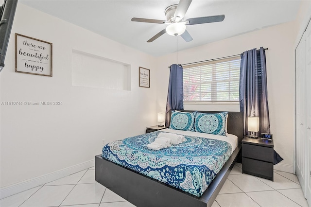 tiled bedroom with ceiling fan and a closet