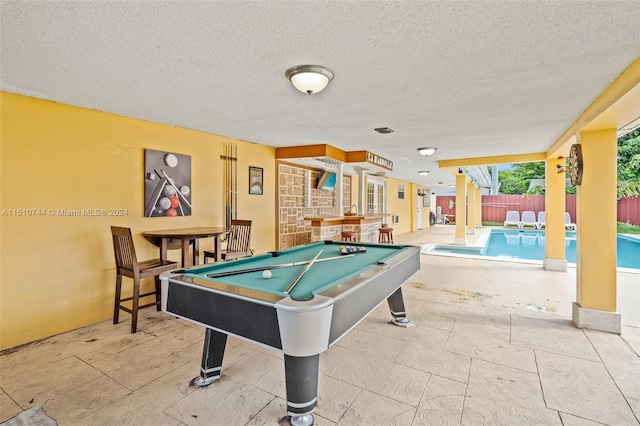 rec room featuring bar, a textured ceiling, and pool table