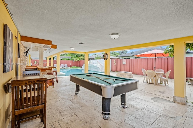 game room featuring light tile patterned flooring, a textured ceiling, and pool table