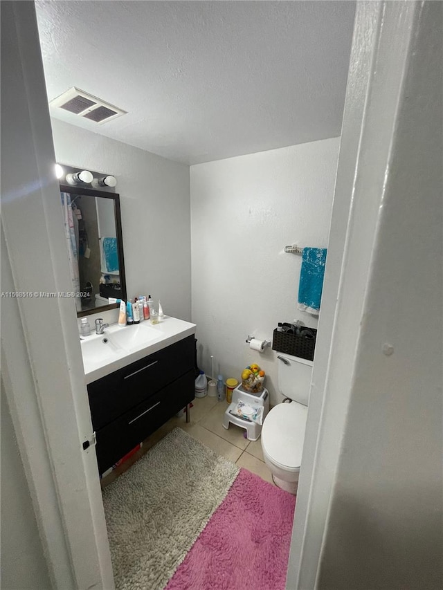 bathroom featuring toilet, tile floors, and vanity