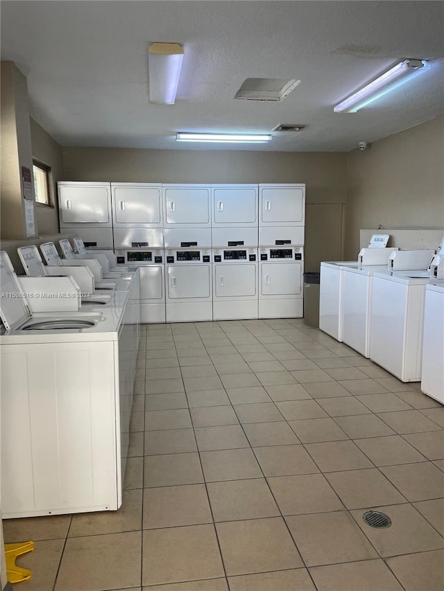 laundry room featuring separate washer and dryer, light tile floors, and stacked washer and clothes dryer