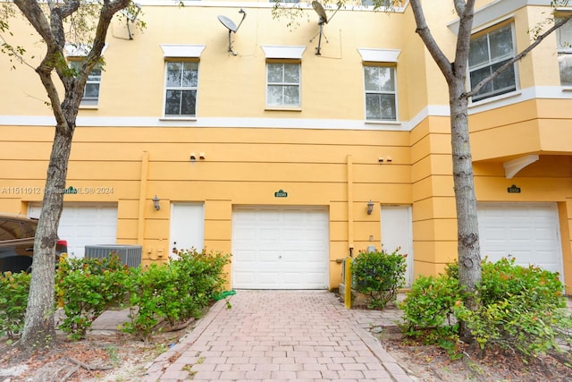 view of front of home featuring a garage and central AC